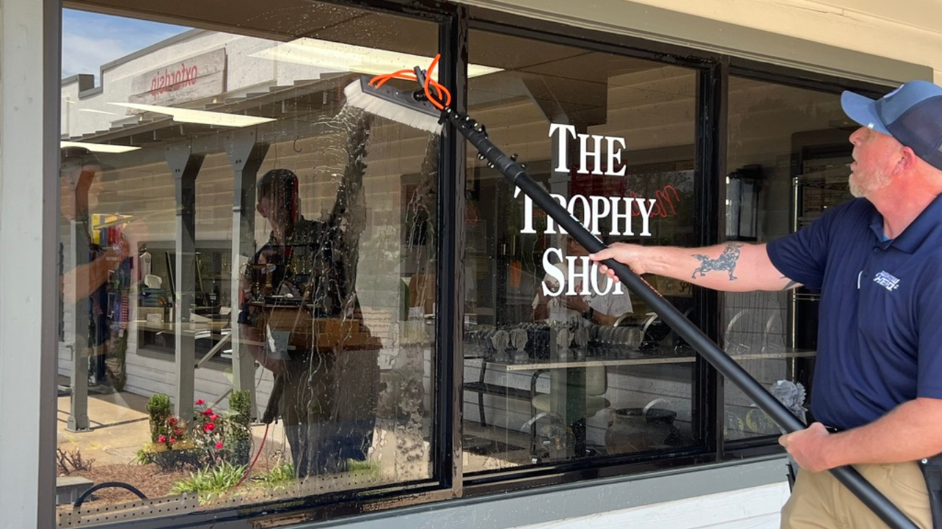 Window Hero professional cleaning a store front window.