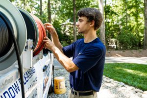 A Window Hero professional tends to the hose stored on his truck.