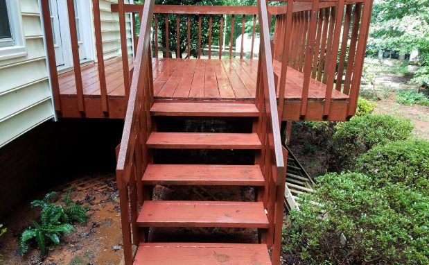 A Window Hero professional pressure washing a large home's exterior surfaces.