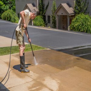 man pressure washing driveway